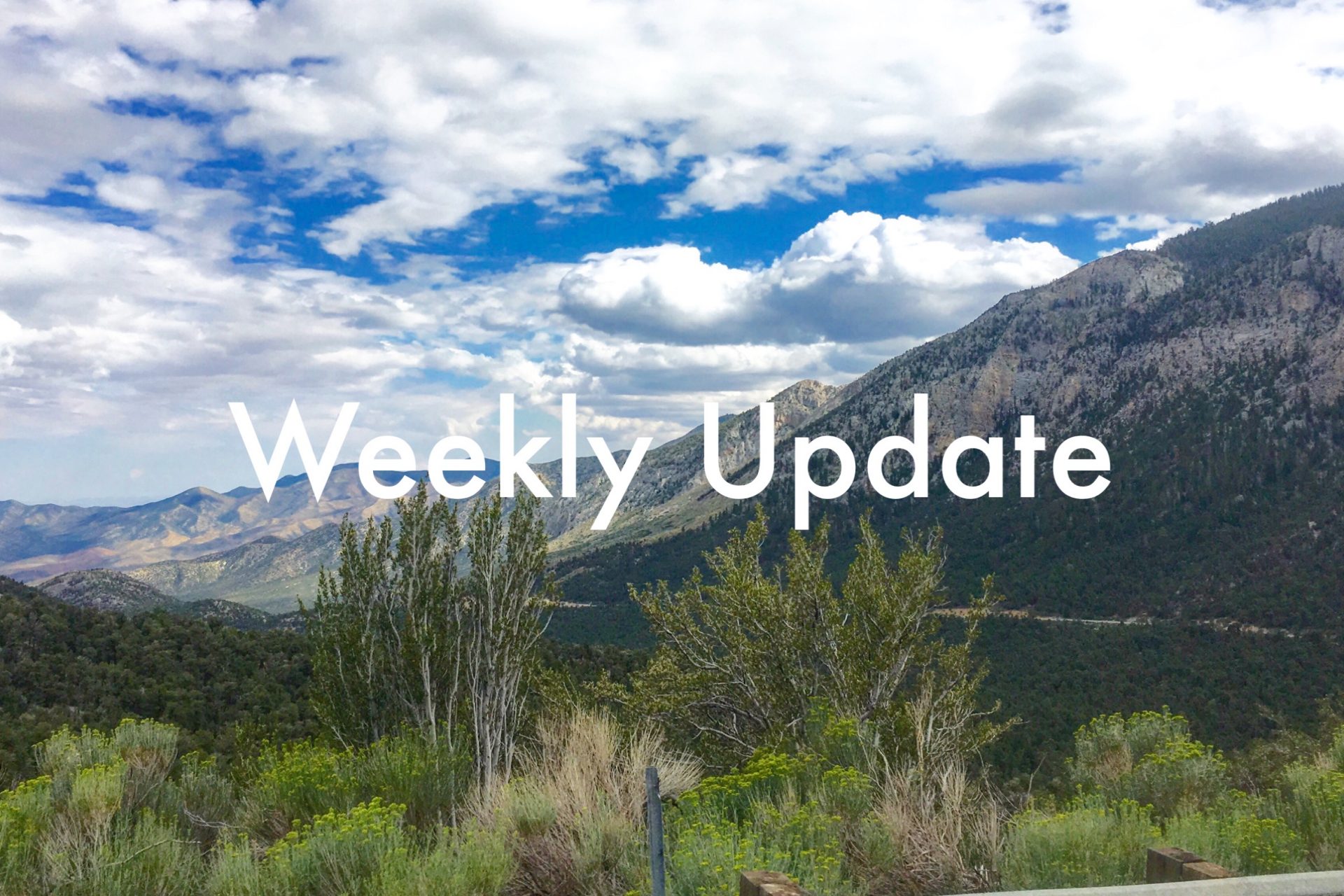 Weekly Update in white text over an expansive mountain vista with highway 158 and puffy clouds in the distance